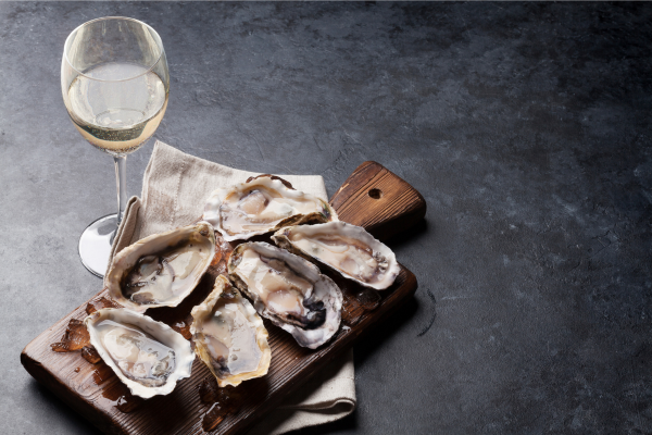 Glass of white wine beside a plate of raw oysters